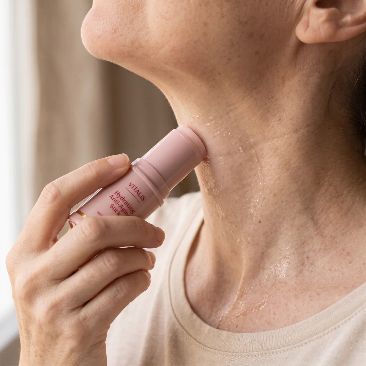 Una mano sube el stick de colágeno por el lateral del cuello